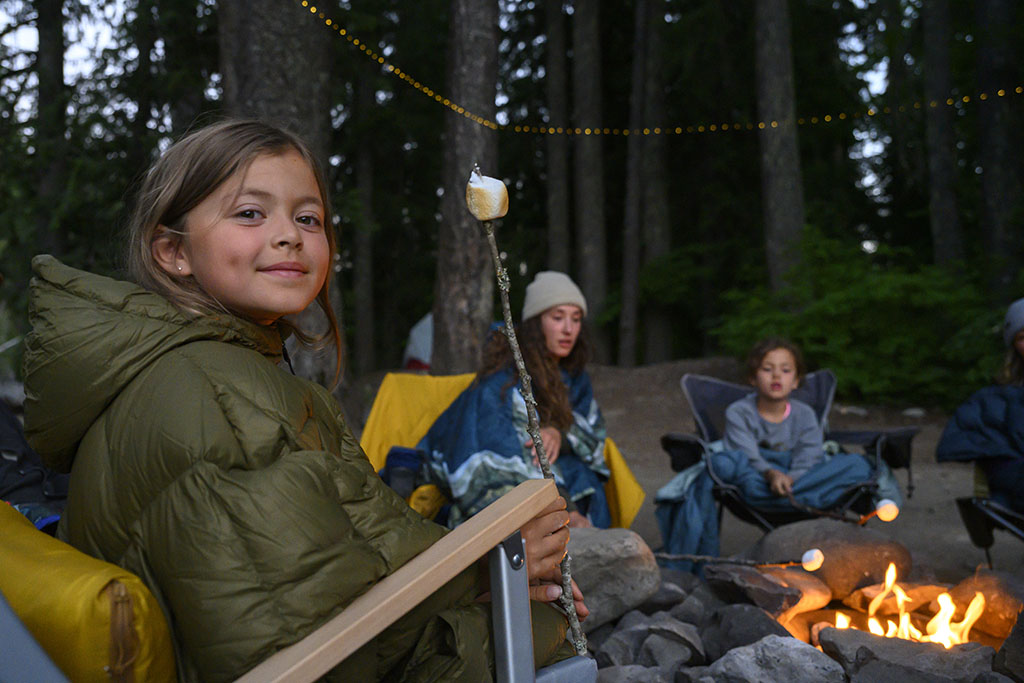 child roasting marshmellow around campfire
