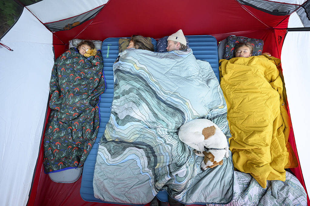 family sleeping in tent on camping trip