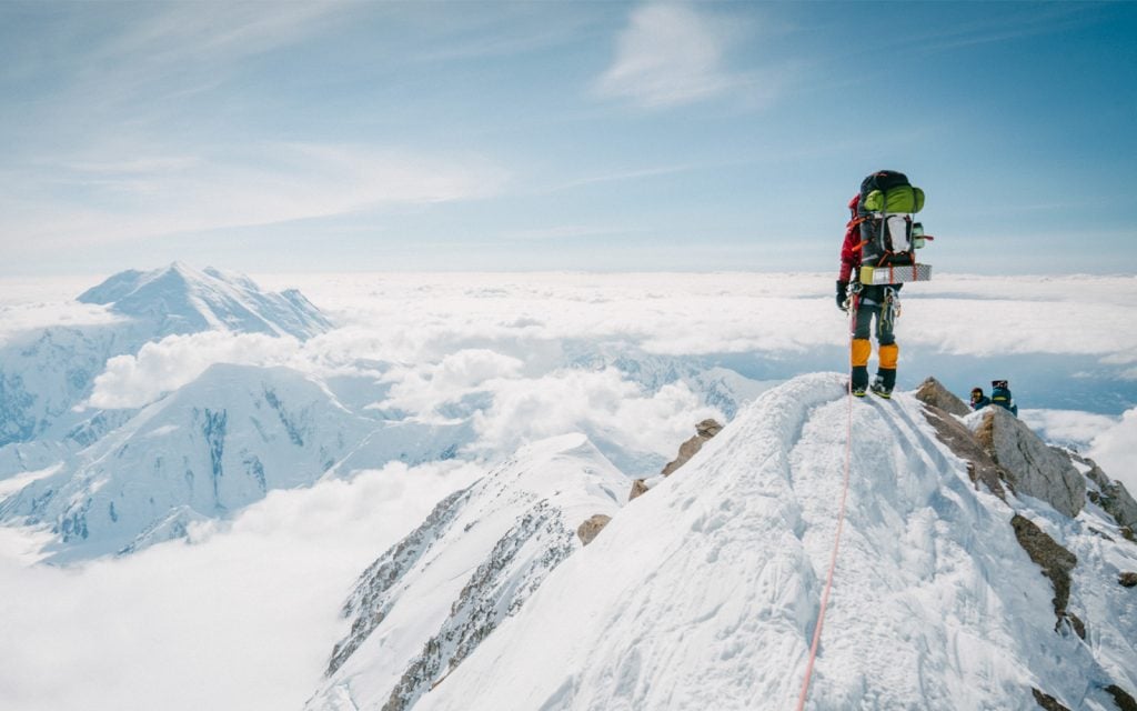 mountaineer at top of peak