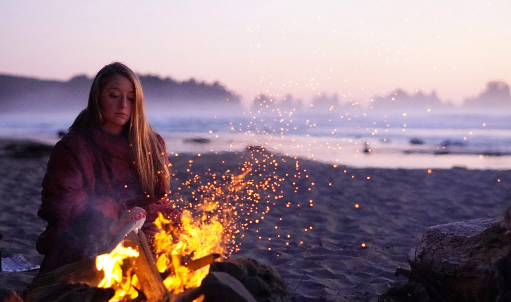 woman at campfire on the beach