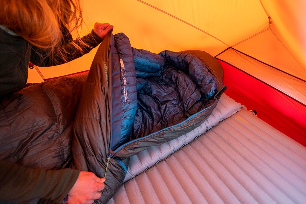 unzipping sleeping bag in tent
