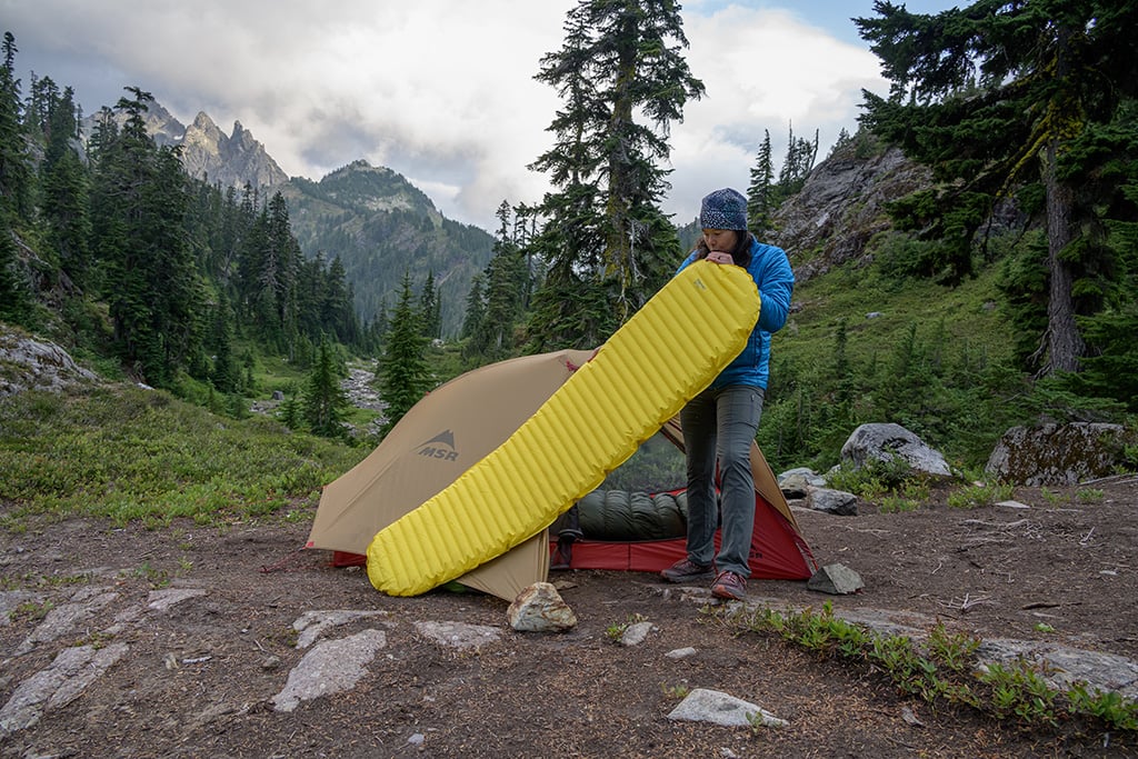 inflating sleeping pad outside of tent