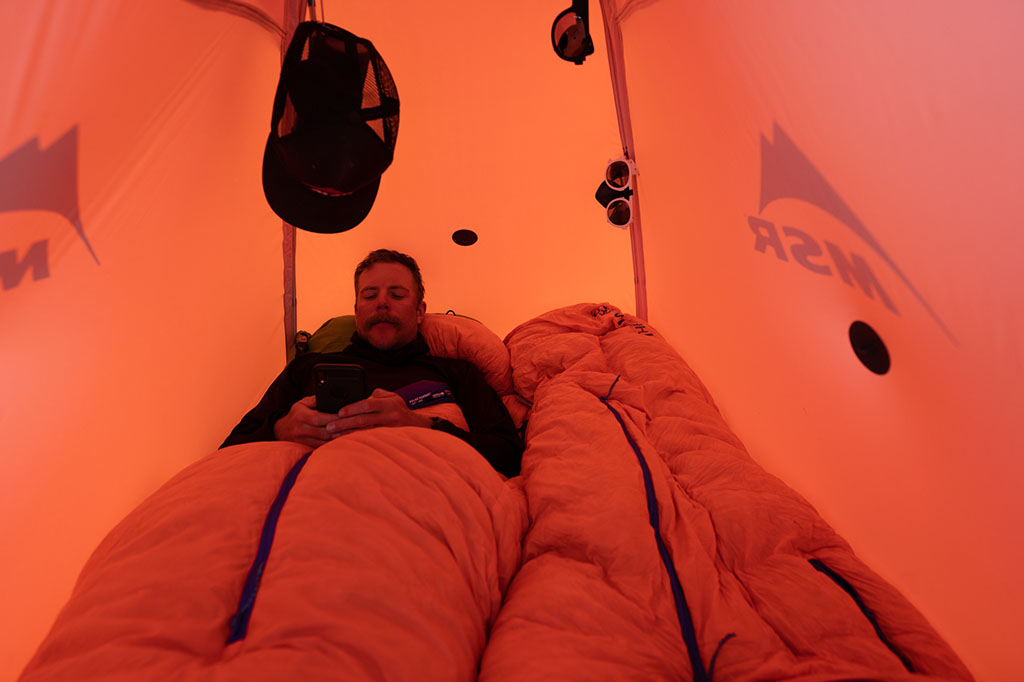 sitting in sleeping bag in tent