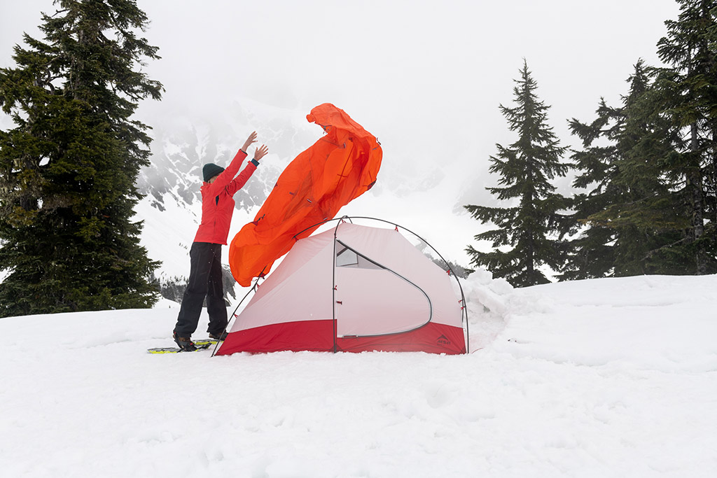 setting up tent in the snow