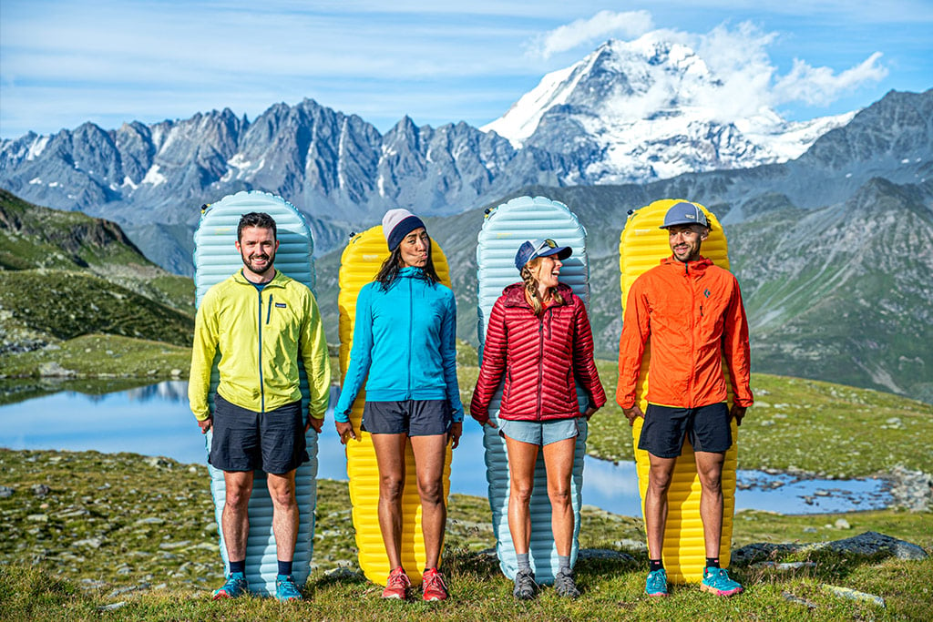 Four people standing in front of Therm-A-Rest sleeping pads.