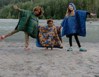 cute kids on a beach wearing fun ponchos
